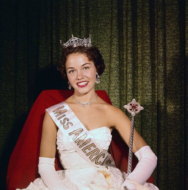 Fleming sitting and smiling and wearing her crown
